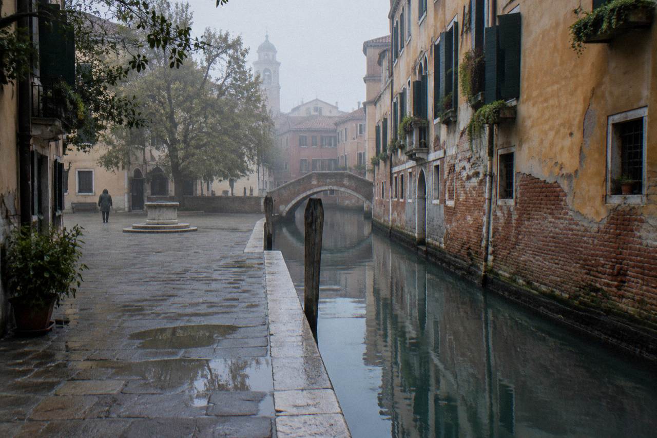 A quiet Venice campiello with a canal and brick facades in morning light