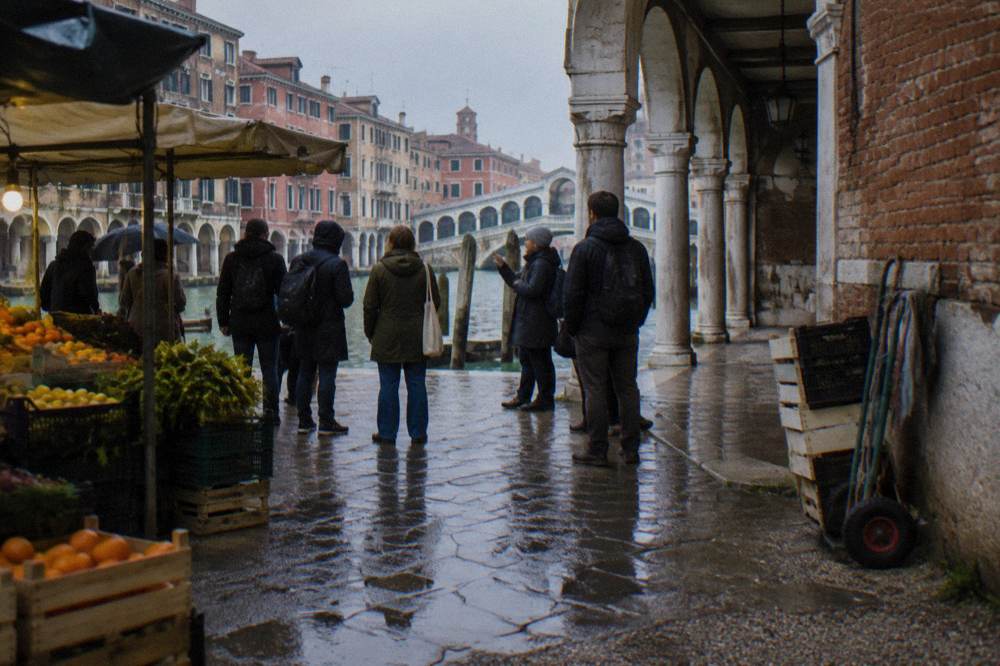 A quiet campo in Venice with a stone well head and faded palace facades