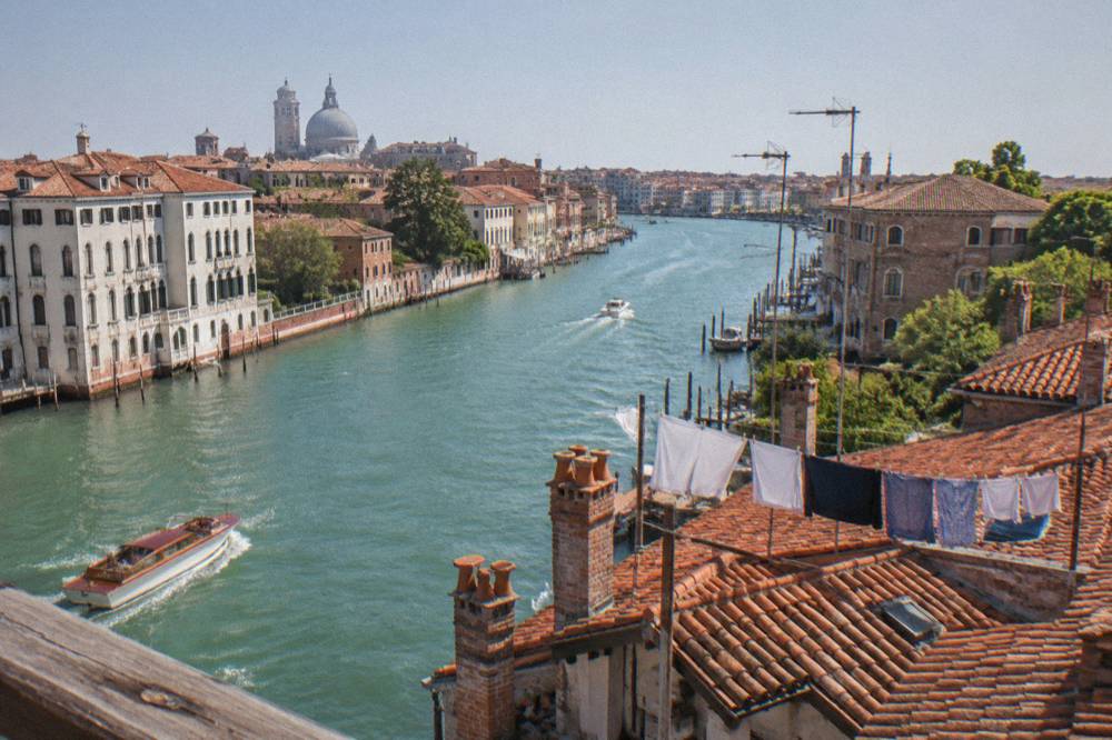 Wide view over Venice rooftops and a canal bending between old palazzi