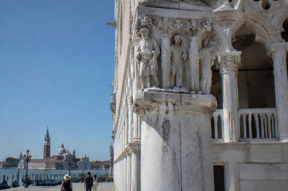 Ornate carved stonework and columns along the waterfront side of the Doge's Palace