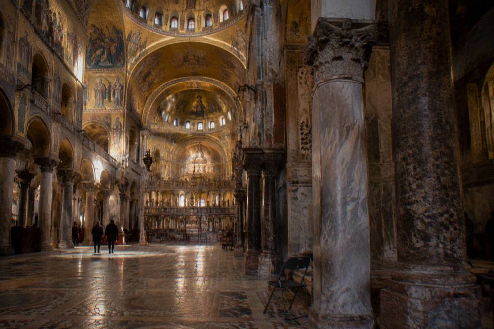 The golden mosaic ceiling inside a Byzantine church nave lit by low warm light