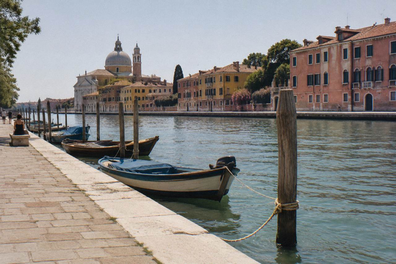 Narrow canal in Venice with moored boats and old brick buildings