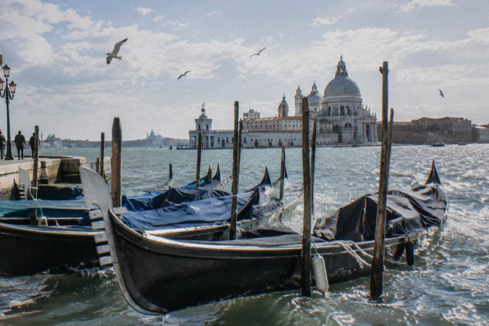 Gondolas moored along a quiet canal in morning light