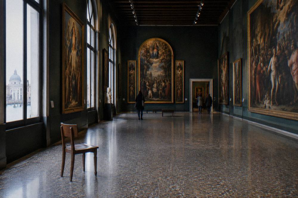 Gallery hall with paintings hung floor to ceiling in a Venetian museum