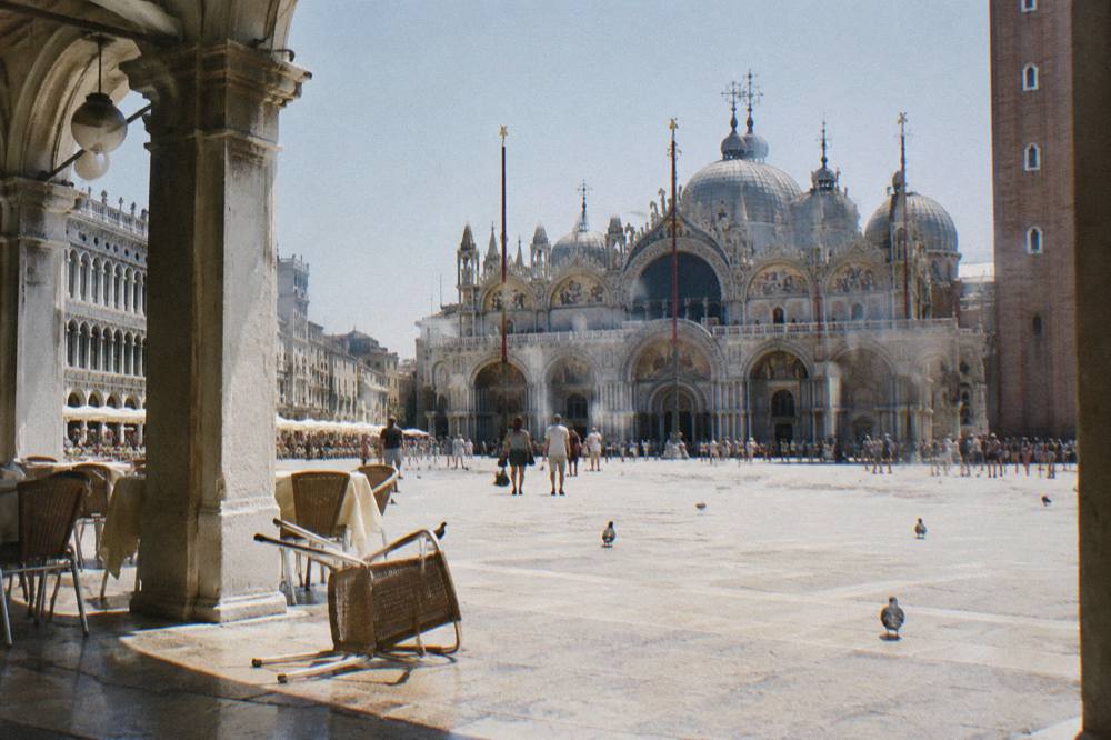 Piazza San Marco under a wide sky with the Basilica facade and arcade columns