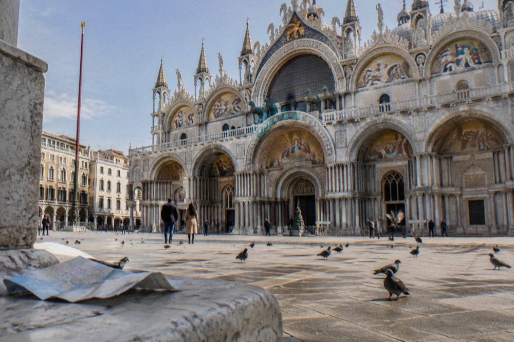 Byzantine church facade with carved arches above a Venice canal