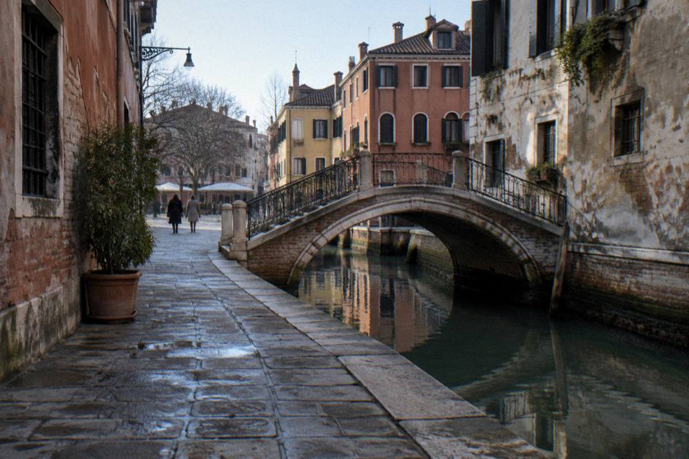 Quiet Venetian alley with footbridge over a narrow canal