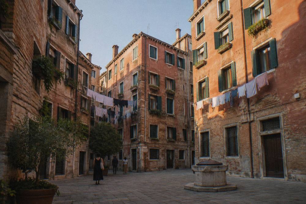 Tall terracotta buildings enclosing a small square in Cannaregio
