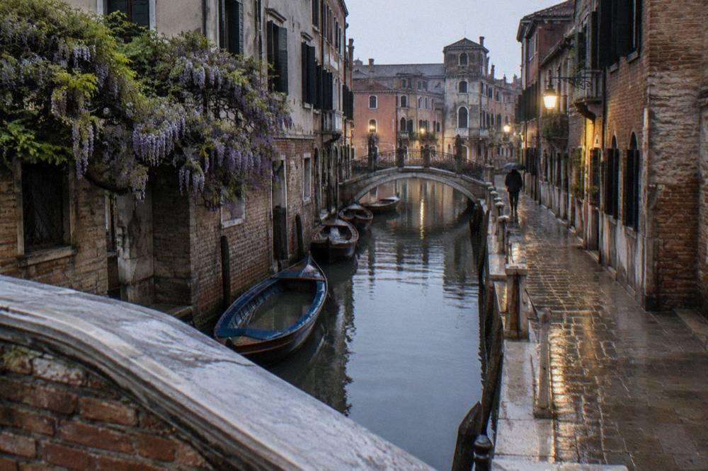 Narrow canal in Cannaregio with a small footbridge and moored boats