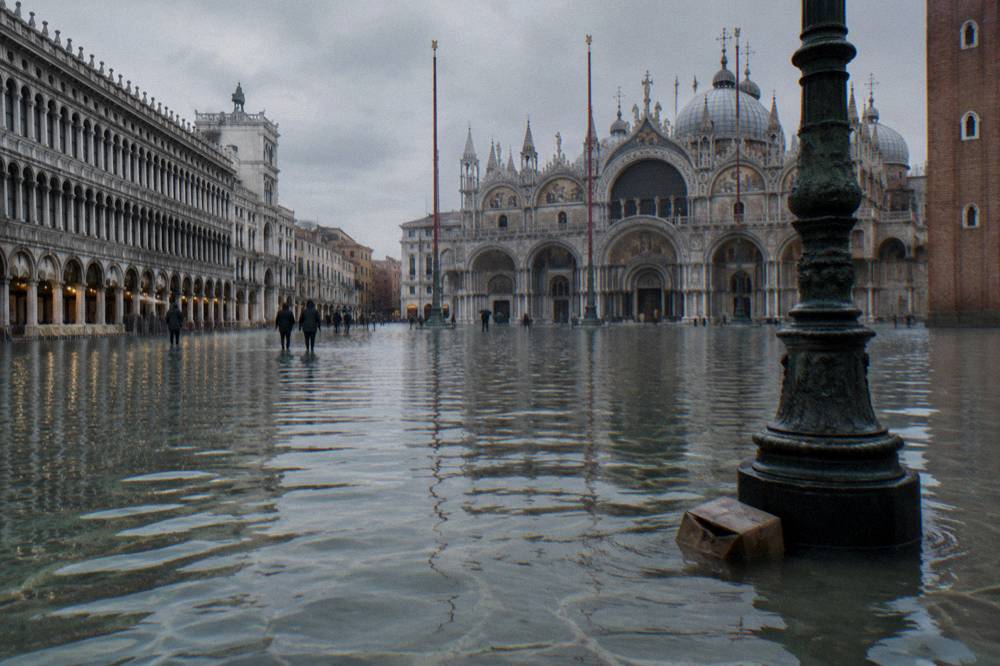Water rising over a paved Venice square at high tide