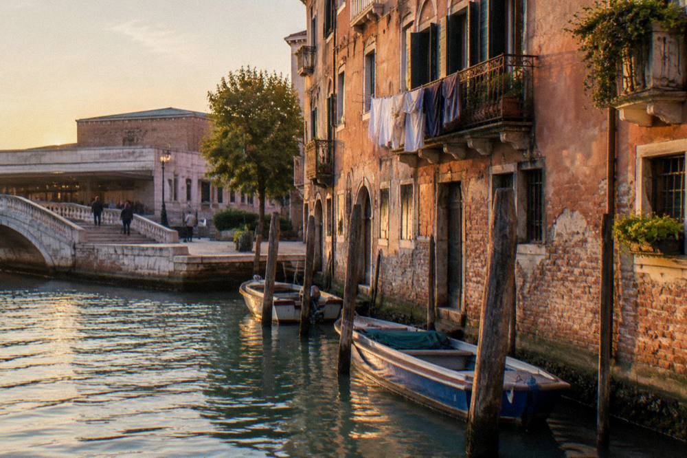A quiet canal in Cannaregio lined with old brick houses and moored boats