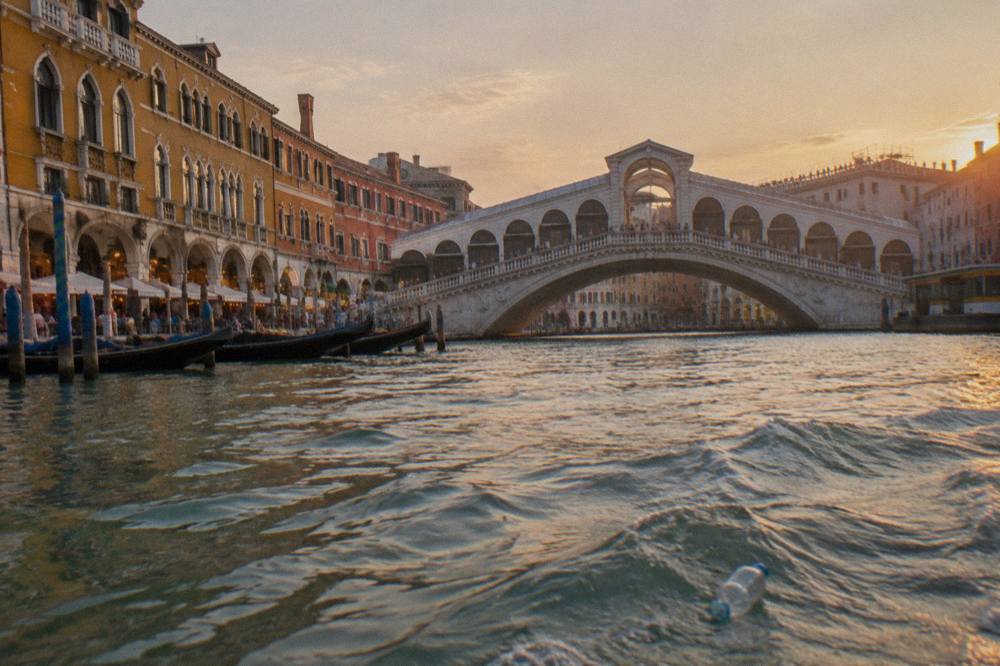 The Rialto Bridge seen from a gondola on the Grand Canal with the arcaded shopfronts along its span