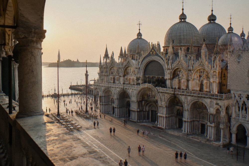 The arched facade and domes of St Mark's Basilica seen from the edge of Piazza San Marco