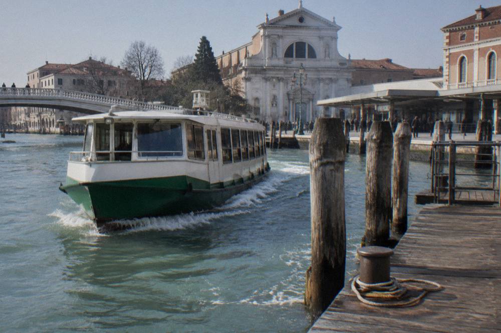 A vaporetto waterbus approaching a wooden landing stage on a Venice canal