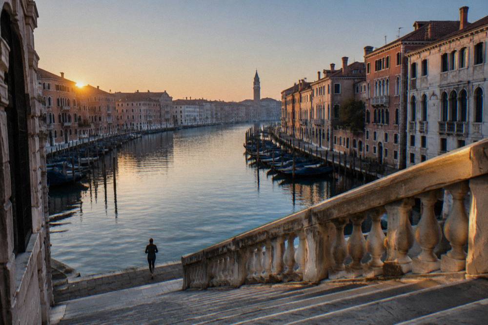 An empty Venice bridge at dawn with the Grand Canal and distant campanile in view