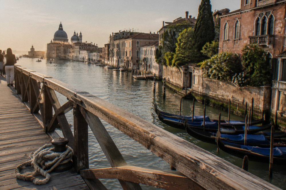 Gondolas moored along a quiet Venice canal beside old stone walls
